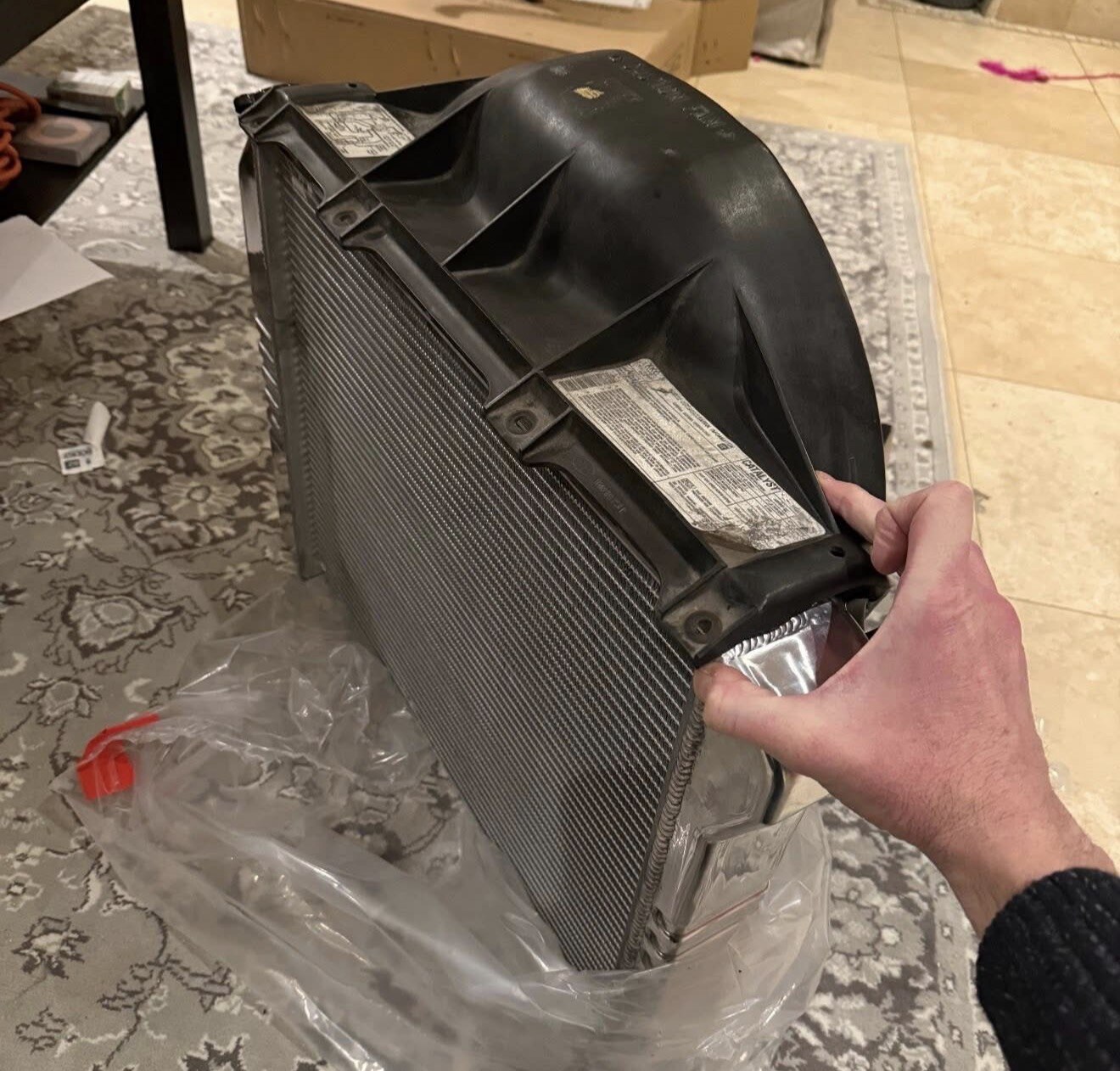 New aluminum radiator with stock fan shroud resting on it — tap to enlarge