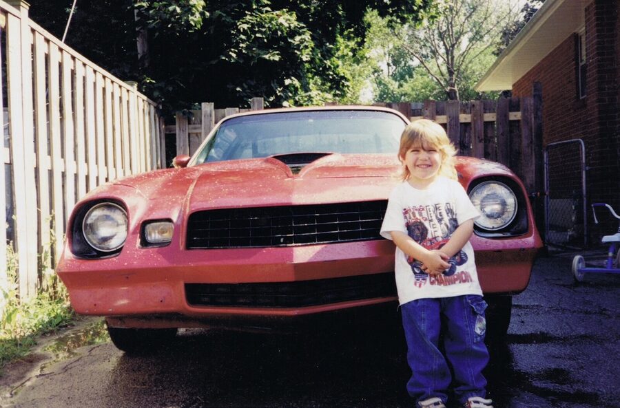 Kid by the front of the red 1978 Camaro Z-28